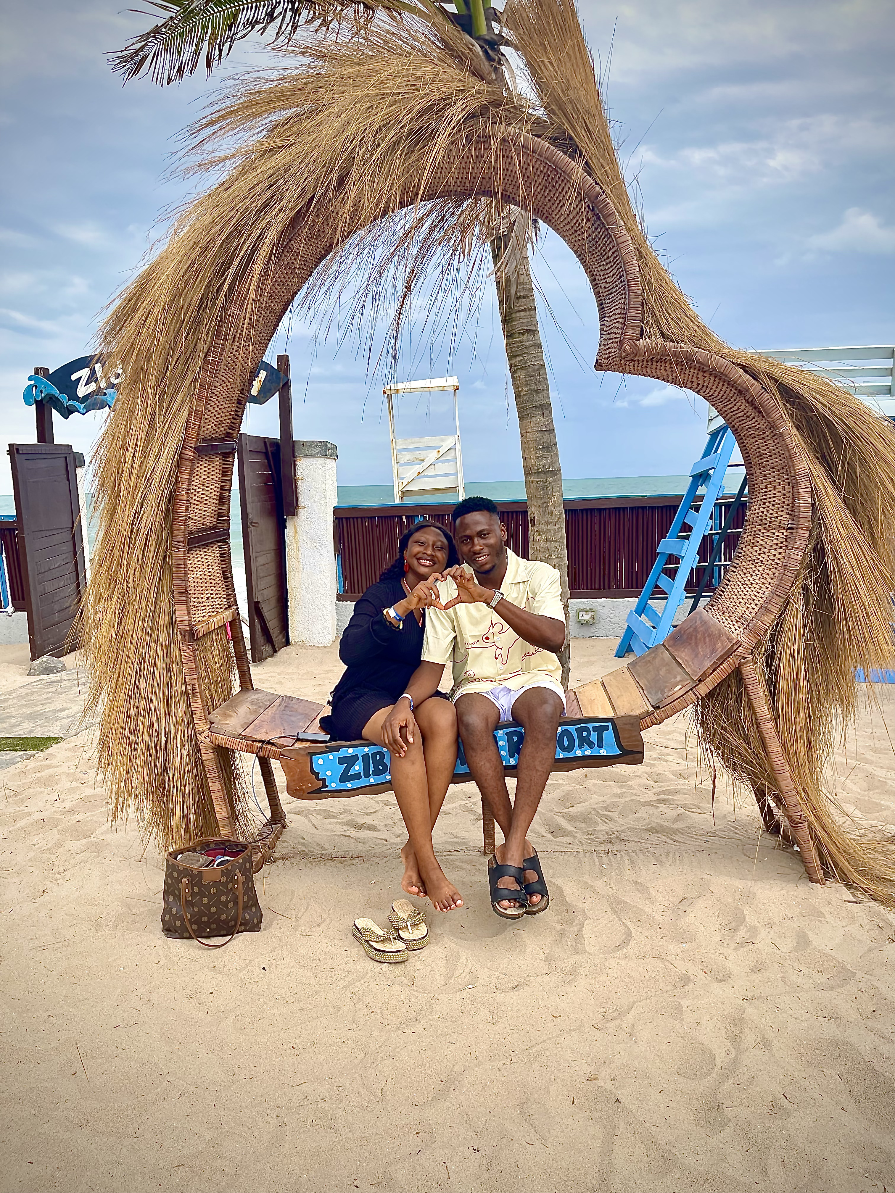 Precious and Emmanuel sitting together by the beach