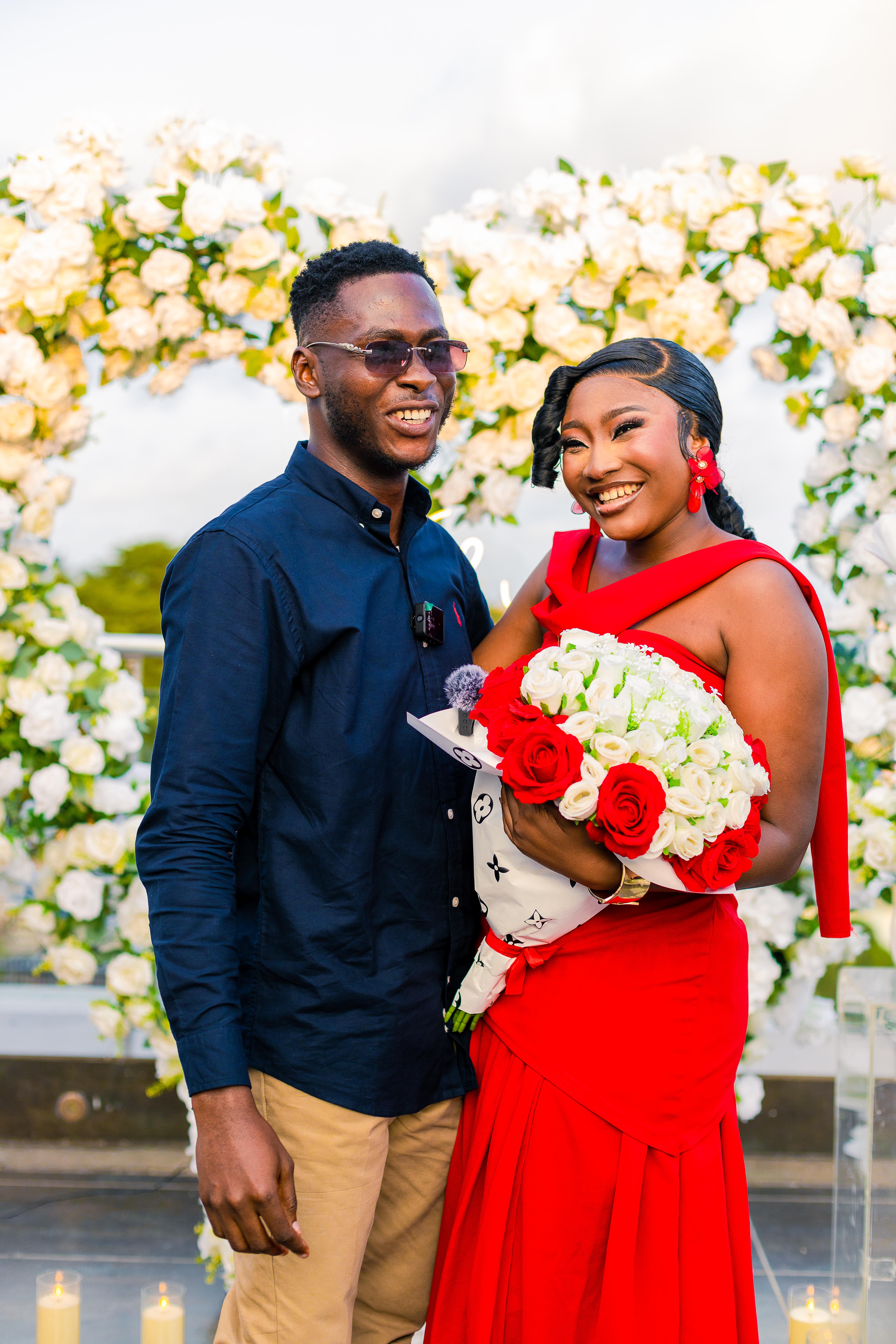 Precious and Emmanuel posing together with her bouquet after the proposal