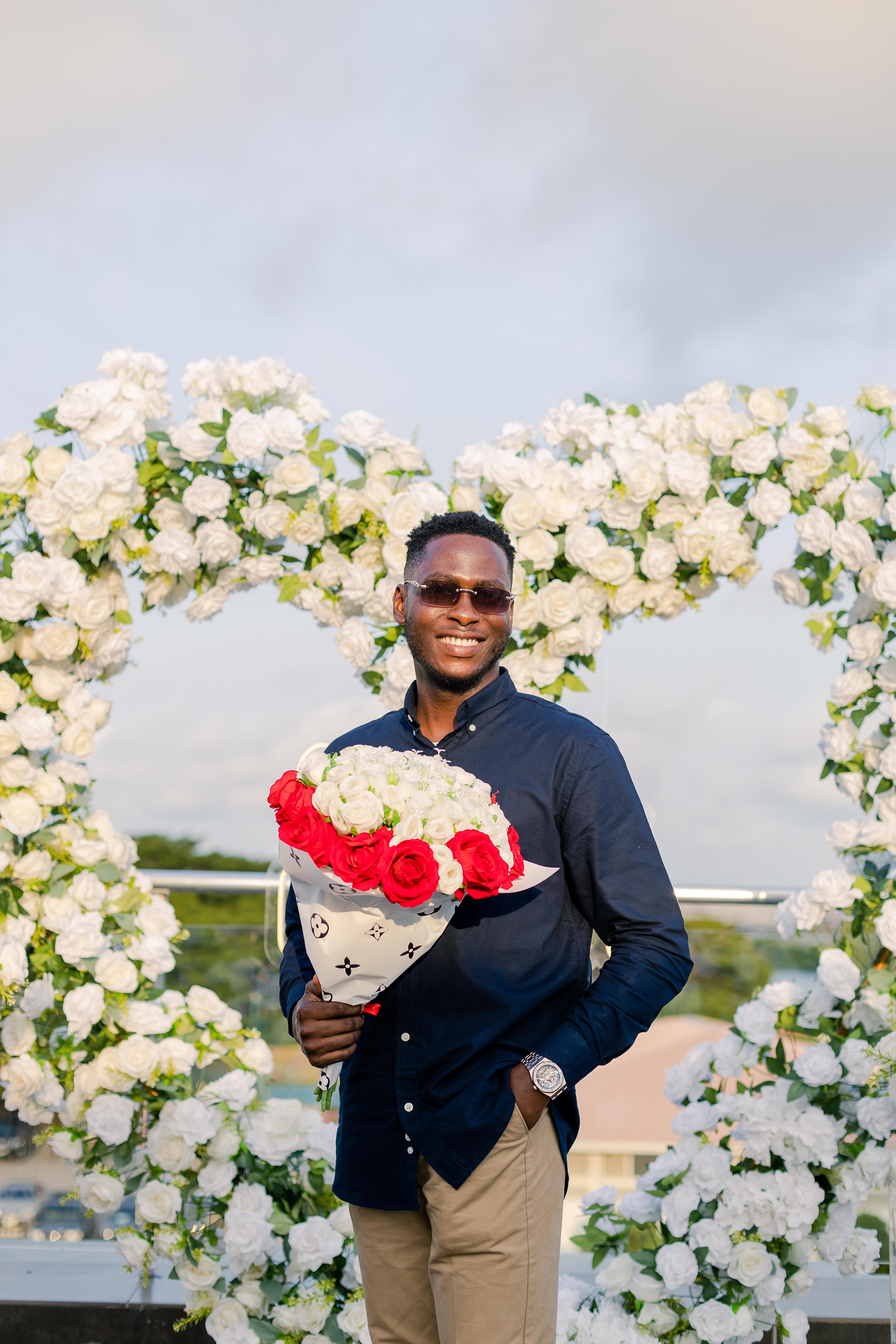 Emmanuel holding a bouquet at the proposal setup
