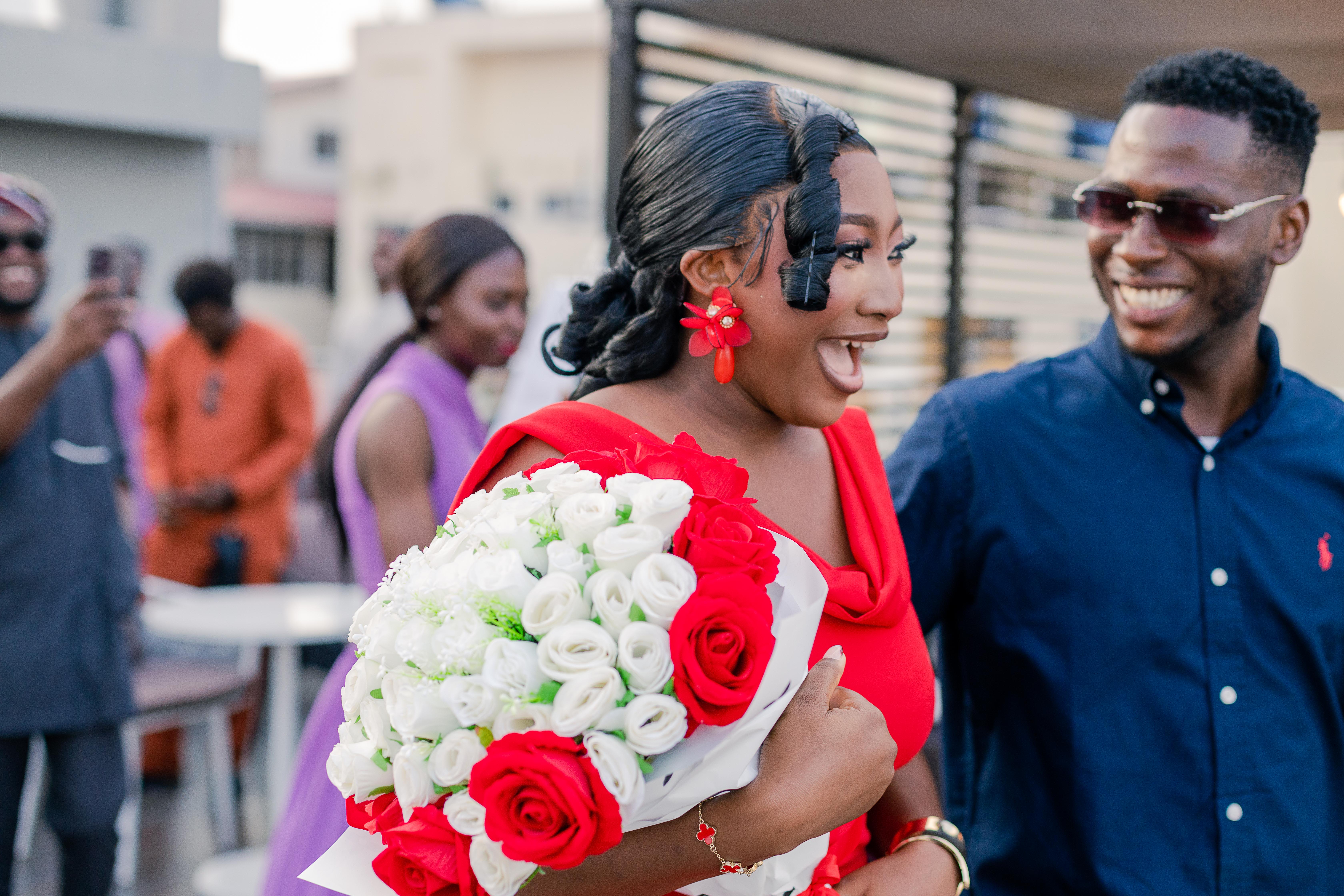 Precious and Emmanuel laughing together at their rooftop engagement celebration